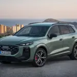 2026 Audi Q3 in green, featuring a redesigned front grille, split LED headlights and sporty alloy wheels.