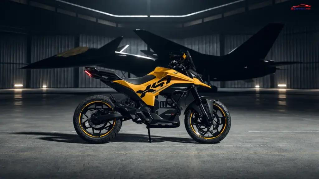 Ultraviolette X47 Venom electric motorcycle in yellow and black parked inside a dimly lit aircraft hangar.