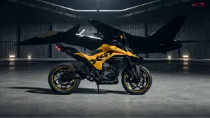 Ultraviolette X47 Venom electric motorcycle in yellow and black parked inside a dimly lit aircraft hangar.